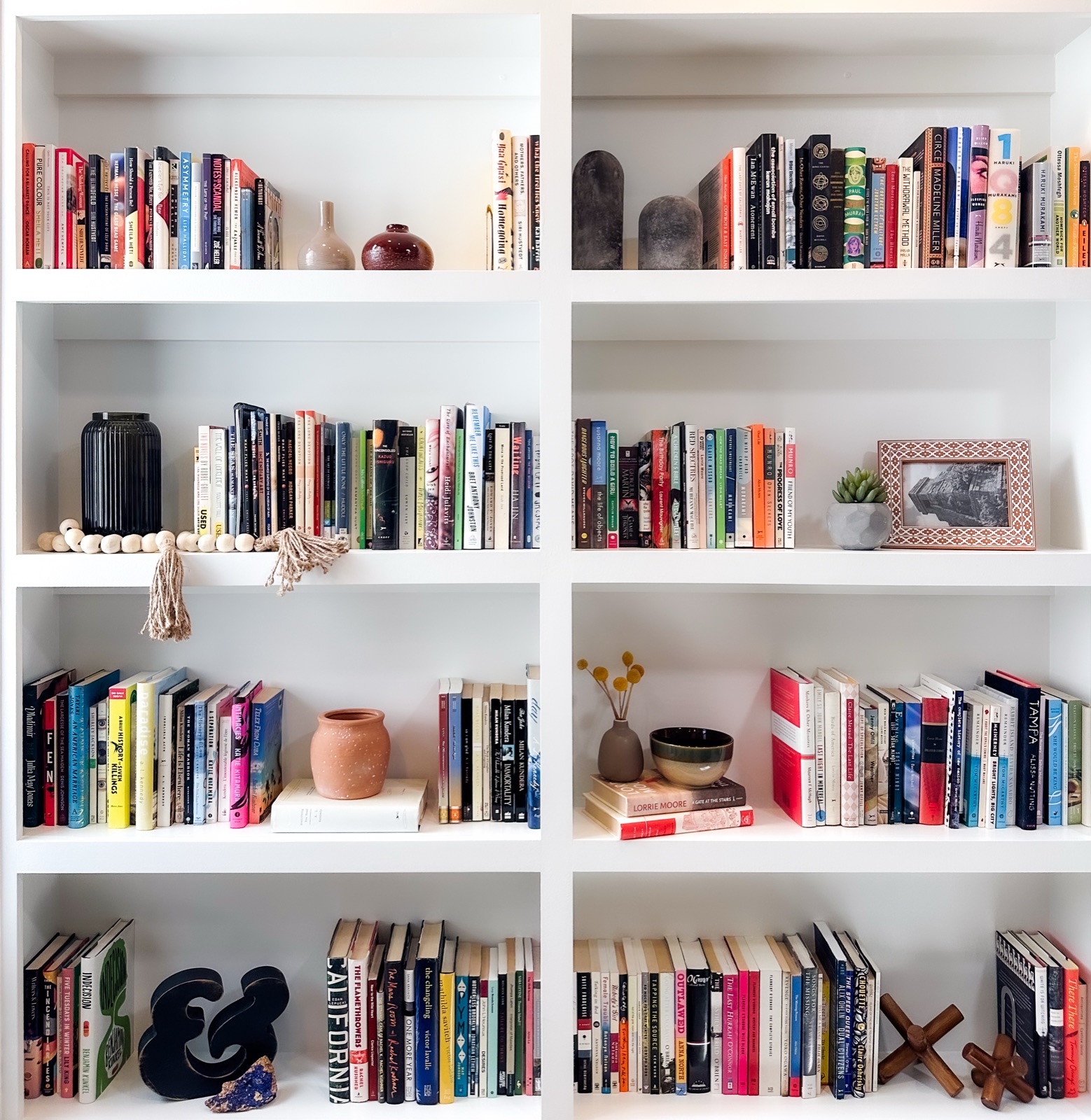 Organized bookshelf with ceramic decor, wood items and design accents