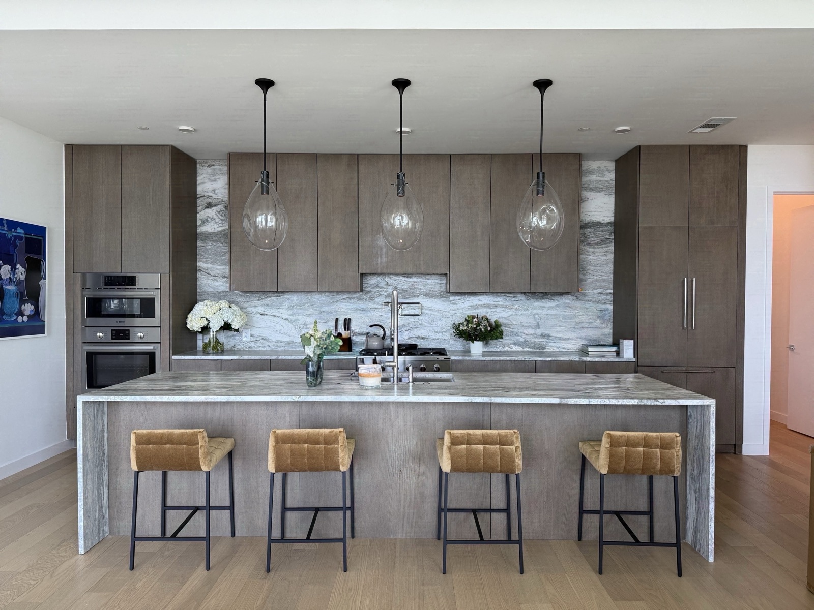 Kitchen island with pendant lighting and stone counters, design by Refinery ATX