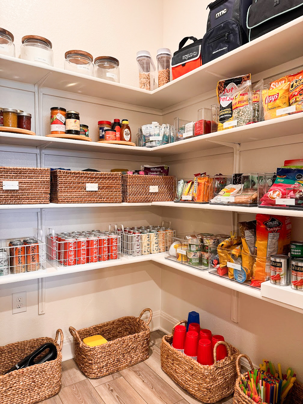 Kitchen pantry organization with baskets and clear plastic bins sorted and labeled