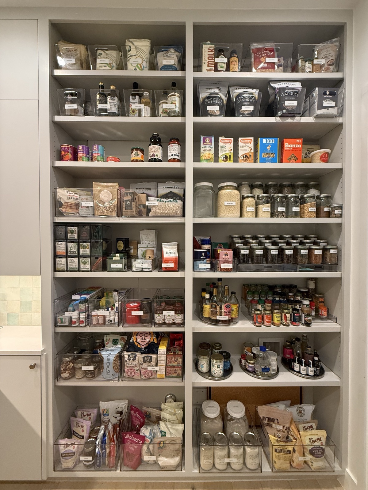 Floor-to-ceiling pantry shelving with labeled bins and glass jars, organized by Refinery ATX in Austin, TX